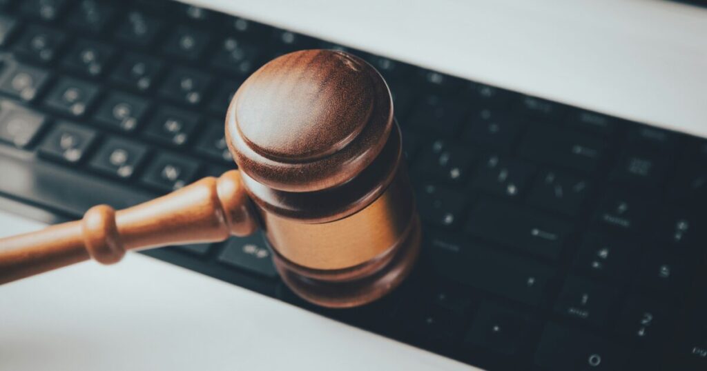 ノートパソコンの上に置かれた木槌。ネットオークションのイメージ